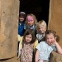 Foto: Fünf Kinder sitzen im Eingang des Speicherbaus unserer eisenzeitlichen Hofanlage.