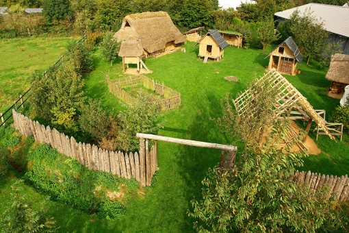 Foto: Luftbild eisenzeitliche Hofanlage mit Gebäuden, umzäuntem Garten und Palisade.