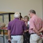 Ausstellungsraum mit Besuchern vor einer Vitrine stehend. Darin ist ein großes Keramikgefäß erkennbar.
