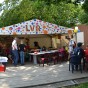 Buntes Zelt mit Aufschrift LVR. Darin  und davor sitzen Kinder an Tischen. Dahinter stehen Bäume.
