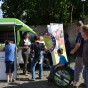 Vor dem LVR-Kulturmobil werden Besucher, davon ein Junge im Rollstuhl, über die Kultureinrichtungen informiert und sie können an einem Glücksrad drehen. 