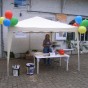 Eine Frau steht unter einem luftballongeschmückten Pavillion.