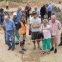 Besucher betrachten ein freigelegtes menschliches Skelett.