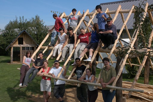 Teilnehmerinnen und Teilnehmer des Workcamps 2006 sitzen und stehen in der Dachkostruktion eines Eisenzeithauses