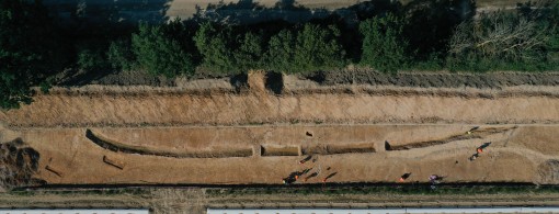 Drohnenfoto: Das Foto zeigt eine Grabungssituation von 2021 aus der Luft. Der Graben ist ausgenommen und gut sichtbar. Zwei Stege sind vorhanden um zusätzliche Profile dokumentieren zu können.